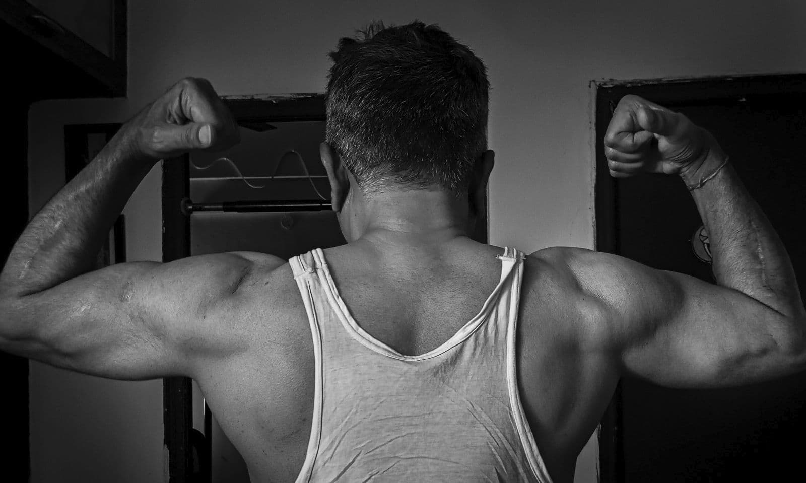 Man in his fifties flexing his back muscles